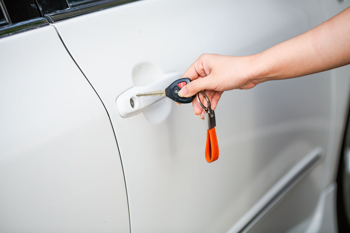Car key beside a white vehicle door